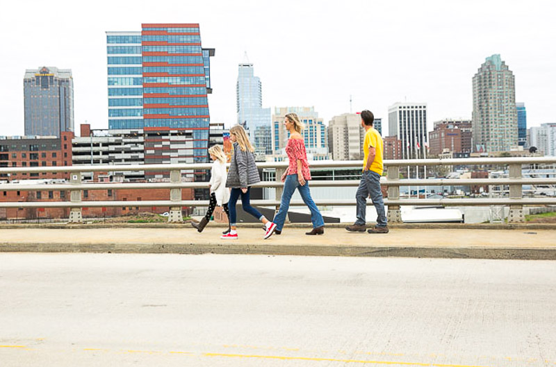 things-to-do-in-downtown-raleigh family crossing boylan bridge with raleigh skyline in background